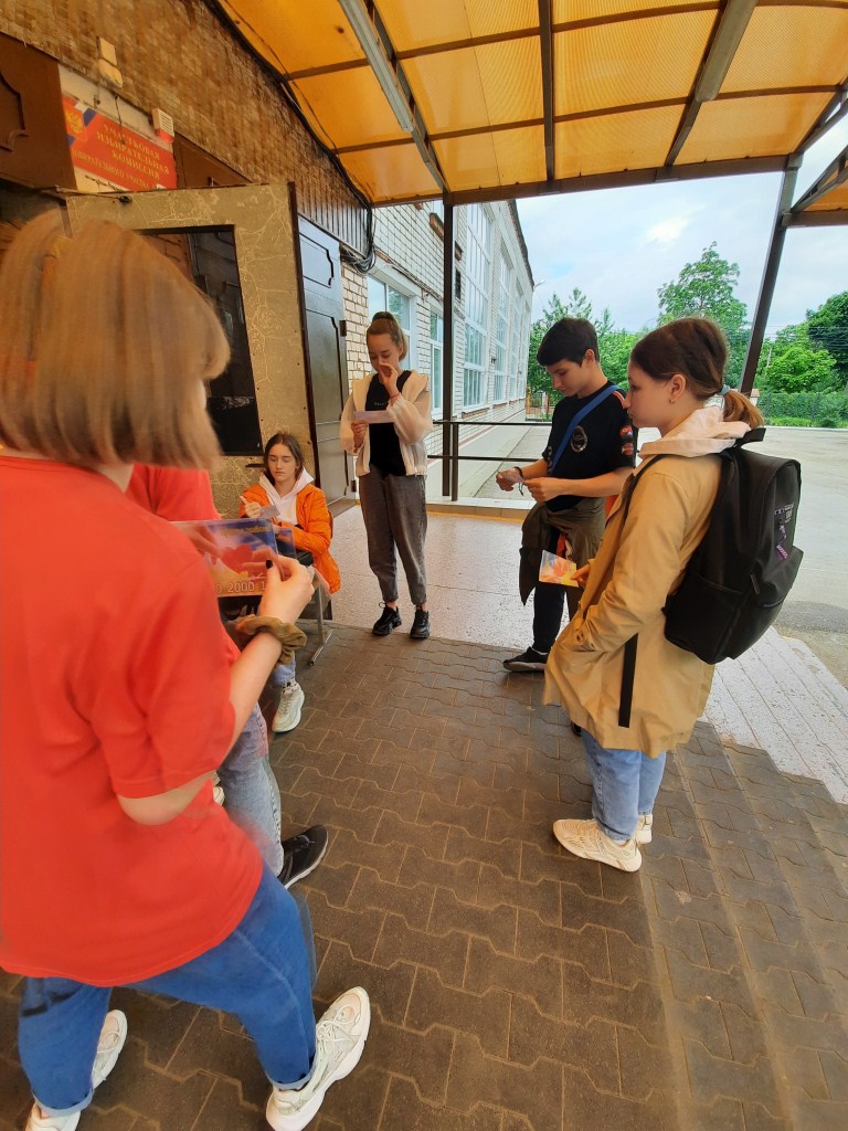 Волонтёры гимназии раздают учащимся листовки о Детском телефоне доверия. 